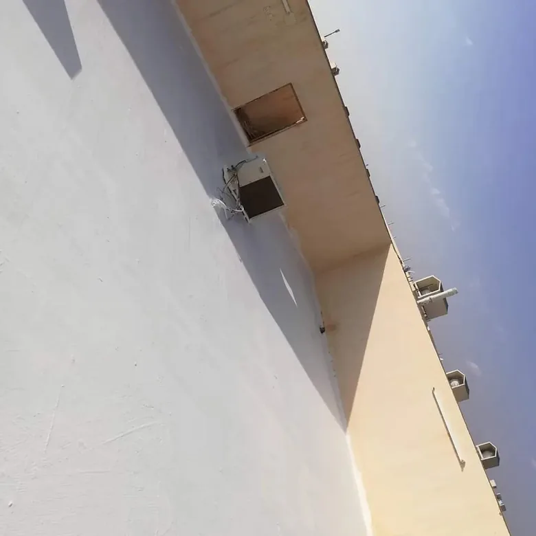 حافة سطح معزول باللون الأبيض بجانب مبنى تحت سماء صافية